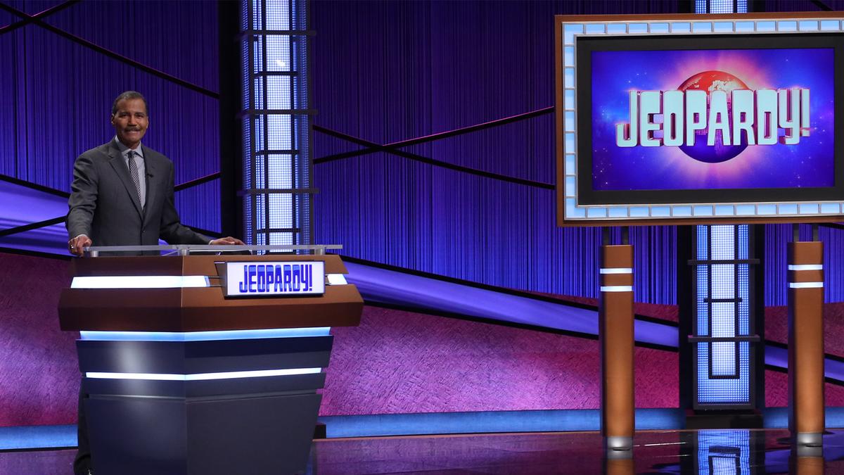Bill Whitaker on the Jeopardy! set, behind the lectern.