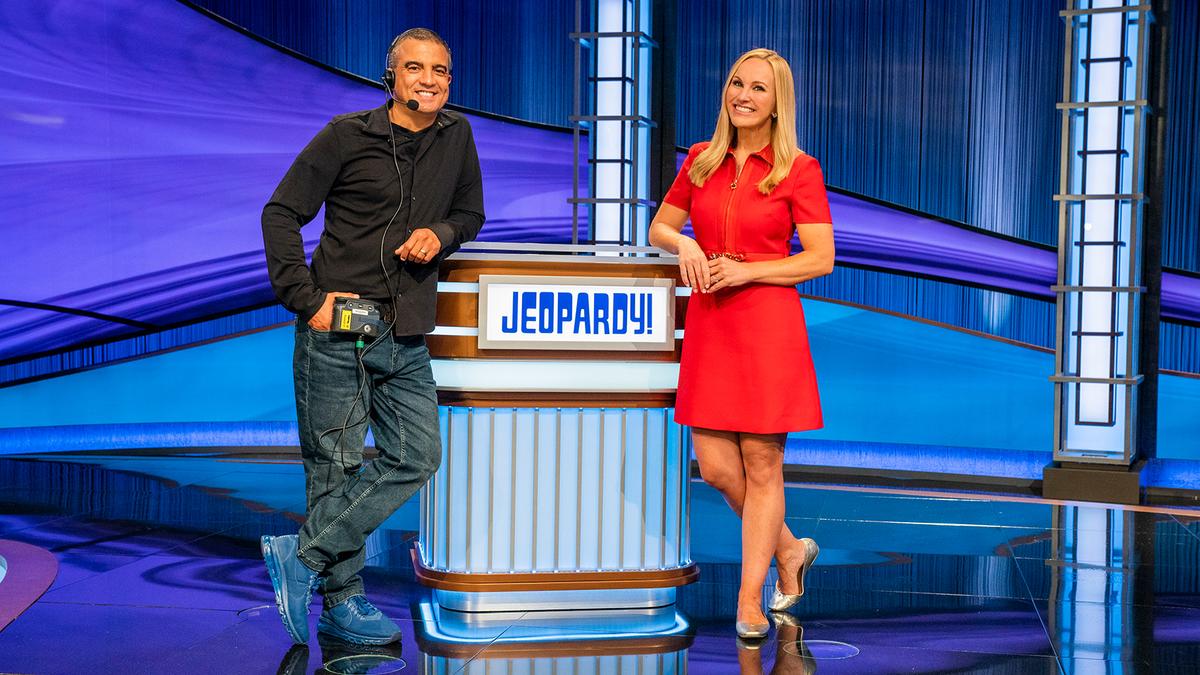 Jimmy McGuire and Sarah Whitcomb Foss in front of the Jeopardy! lectern