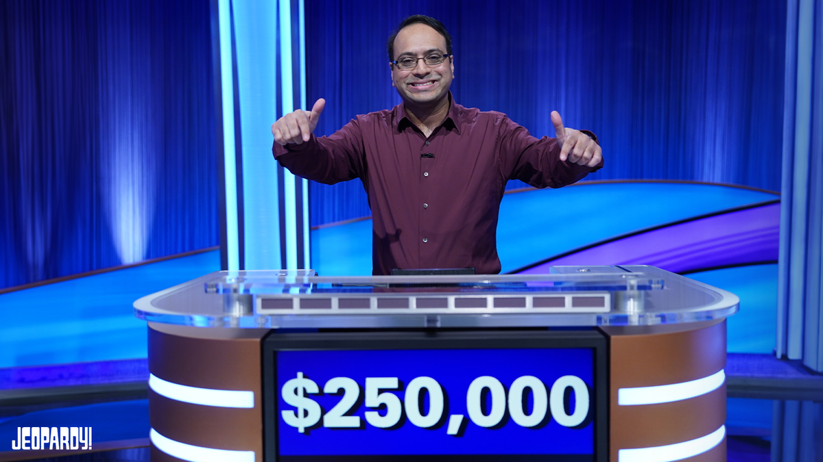Yogesh Raut points at his winning $250,000 total on contestant podium