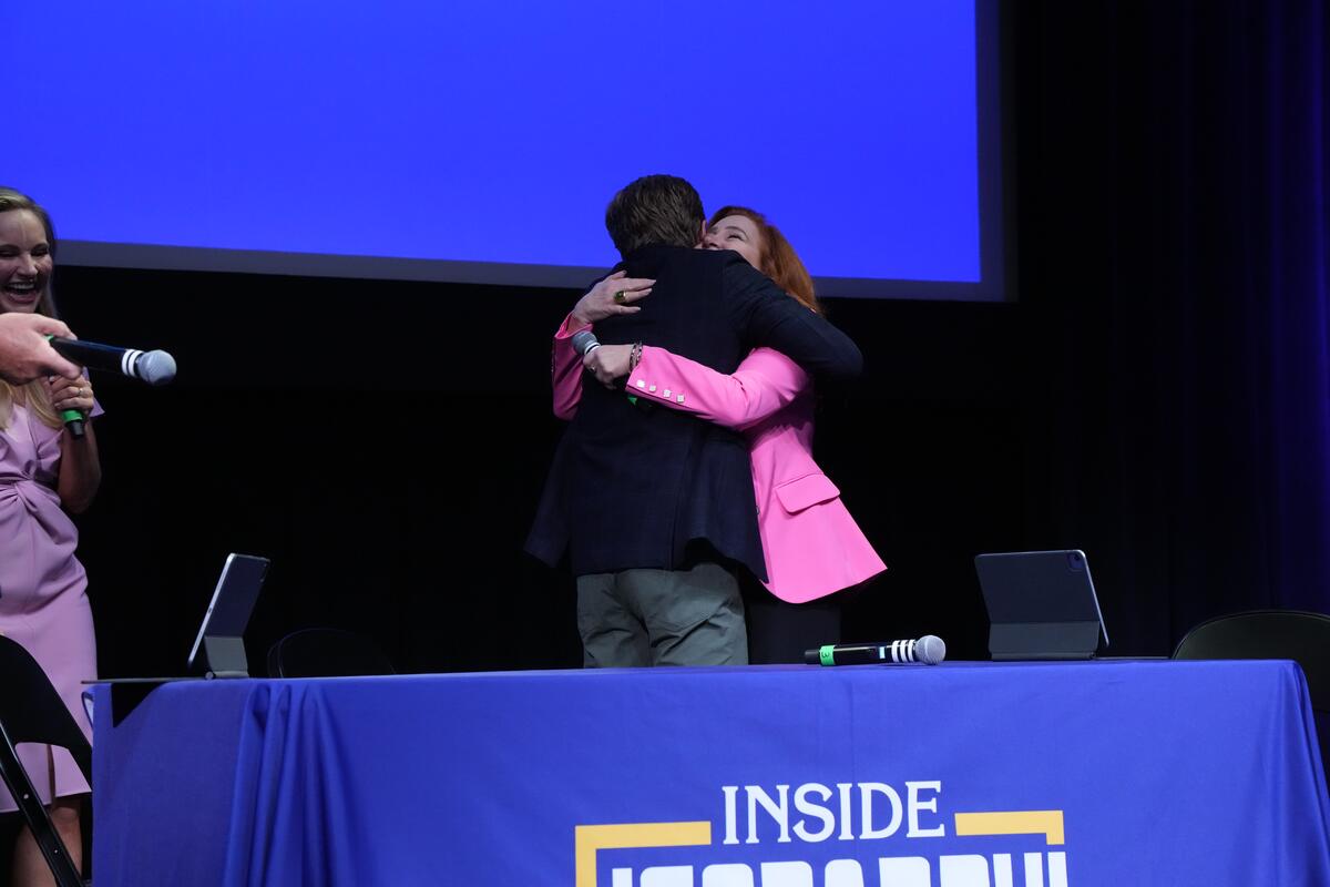 Drew Goins and Lisa Ann Walter hugging on stage during the Inside Jeopardy! Live on Tour. 