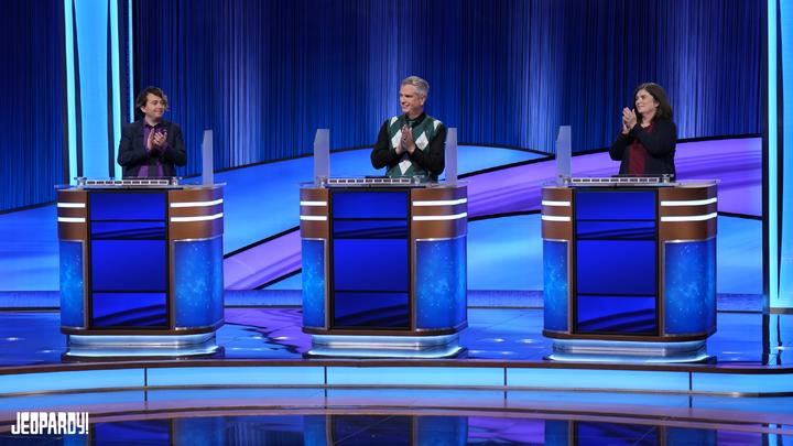 Jeopardy! Second Chance Season 37 contestants Cody Lawrence, David Mayor, and Susan Schulman on set behind their contestant podiums.