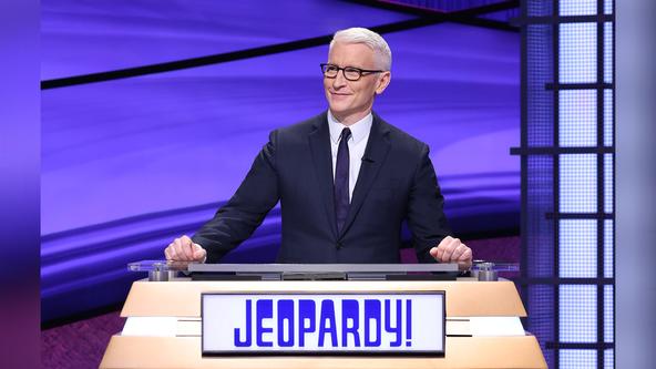 Anderson Cooper behind the Jeopardy! lectern