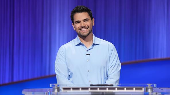 Cris Pannullo stands at the Jeopardy! contestant podium 