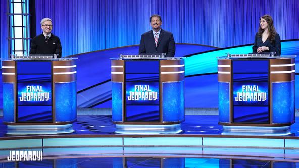 Contestants Dan Wohl, Scott Perry, and Mira Hayward on set behind their contestant podiums.