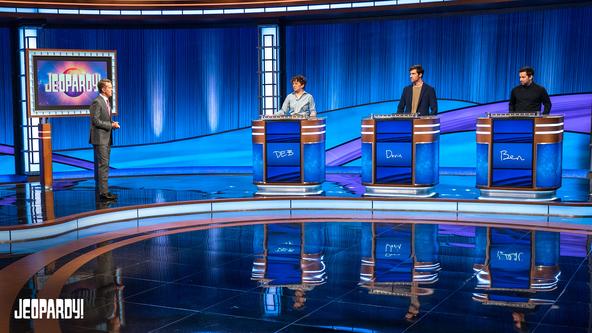 Ken Jennings and contestants Deb Bilodeau, Devin Lohman, and Ben Spilsbury on set.